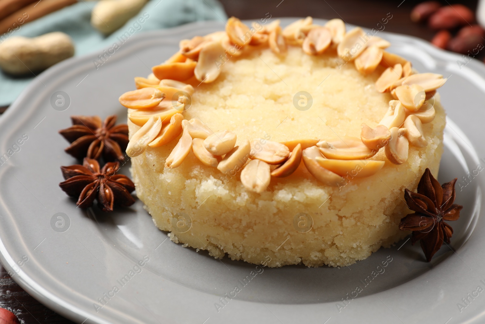 Photo of Delicious semolina halva with almond flakes and spices on table, closeup