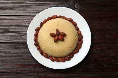 Photo of Delicious semolina halva with almonds on wooden table, top view