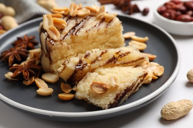 Photo of Delicious sweet semolina halva with peanuts and spices on white table, closeup