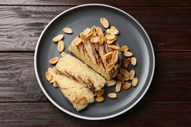 Photo of Delicious sweet semolina halva with peanuts on wooden table, top view