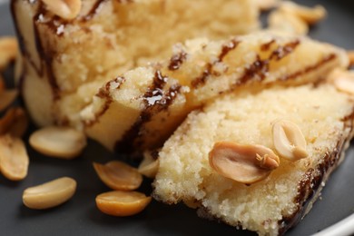 Photo of Delicious sweet semolina halva with peanuts on plate, closeup