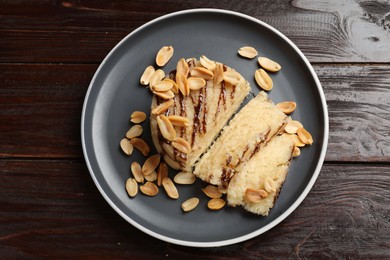 Photo of Delicious sweet semolina halva with peanuts on wooden table, top view