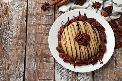 Photo of Delicious sweet semolina halva with pecans and spices on wooden table, flat lay. Space for text