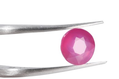 Photo of Tweezers with shiny pink gemstone isolated on white