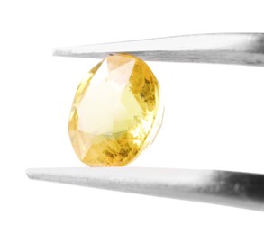 Photo of Tweezers with shiny yellow gemstone isolated on white