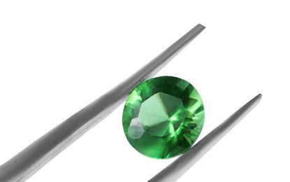 Photo of Tweezers with shiny green gemstone isolated on white