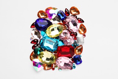 Photo of Different shiny gemstones on white background, top view