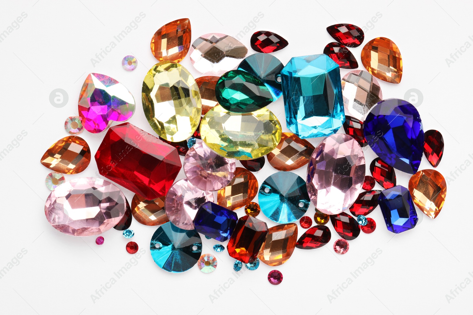 Photo of Different shiny gemstones on white background, top view