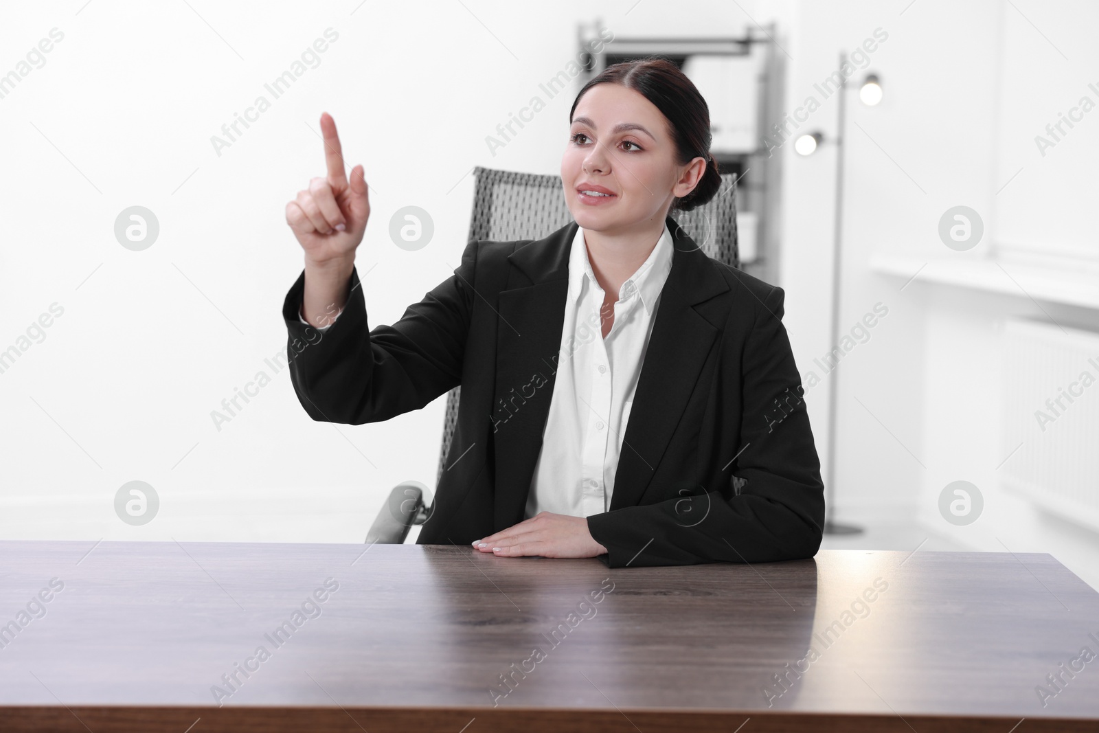 Photo of Beautiful woman pointing at something in office