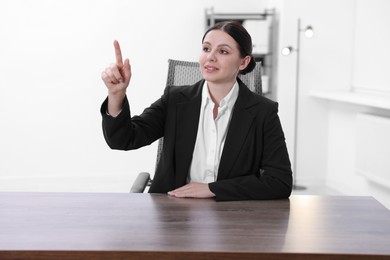 Beautiful woman pointing at something in office