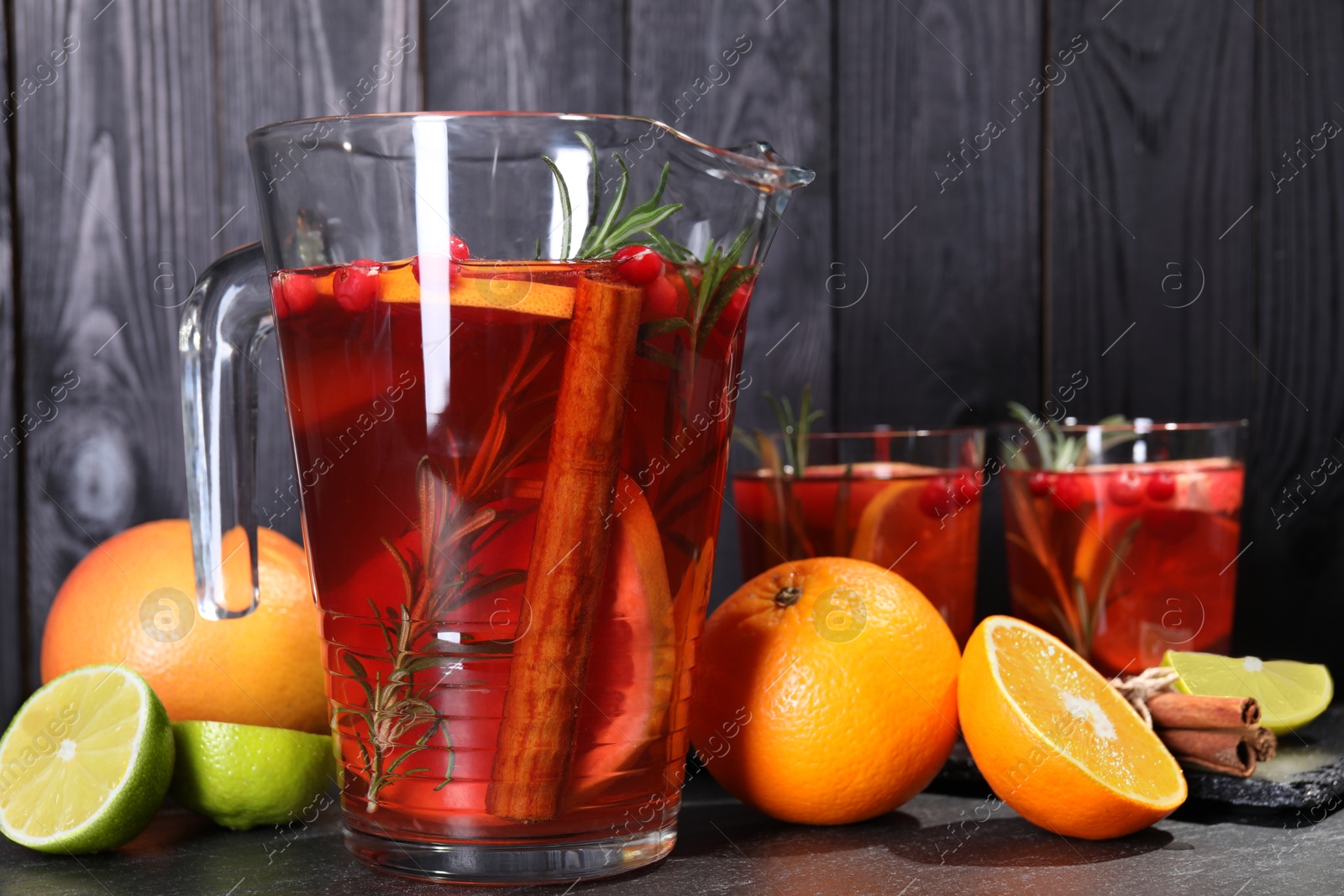 Photo of Delicious punch and ingredients on black table