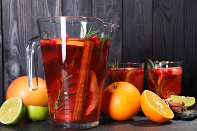 Photo of Delicious punch and ingredients on black table