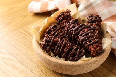 Delicious chocolate puffed rice bars on wooden table, closeup. Space for text