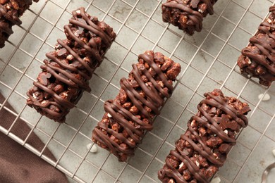 Photo of Delicious chocolate puffed rice bars on gray textured table, top view