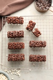 Delicious chocolate puffed rice bars and candies on gray textured table, flat lay