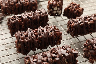 Photo of Delicious chocolate puffed rice bars on gray textured table, closeup