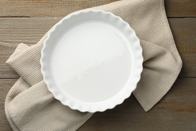 Photo of One ceramic casserole on wooden table, top view