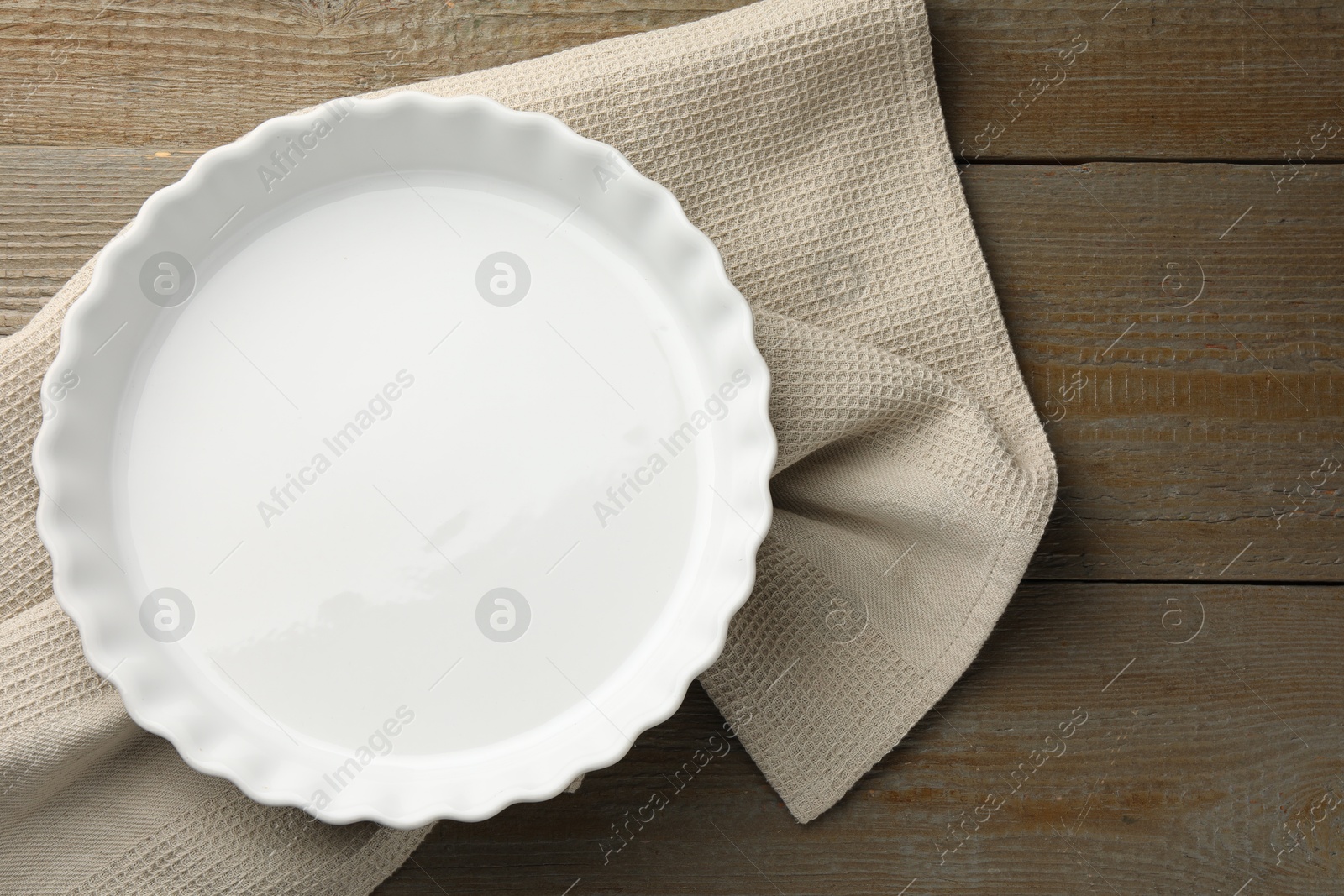 Photo of One ceramic casserole on wooden table, top view. Space for text