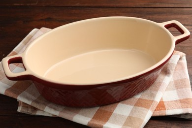 Photo of One ceramic casserole on wooden table, closeup