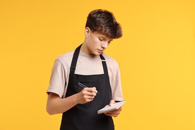 Photo of Boy with notepad taking order in cafe. Work for teenagers