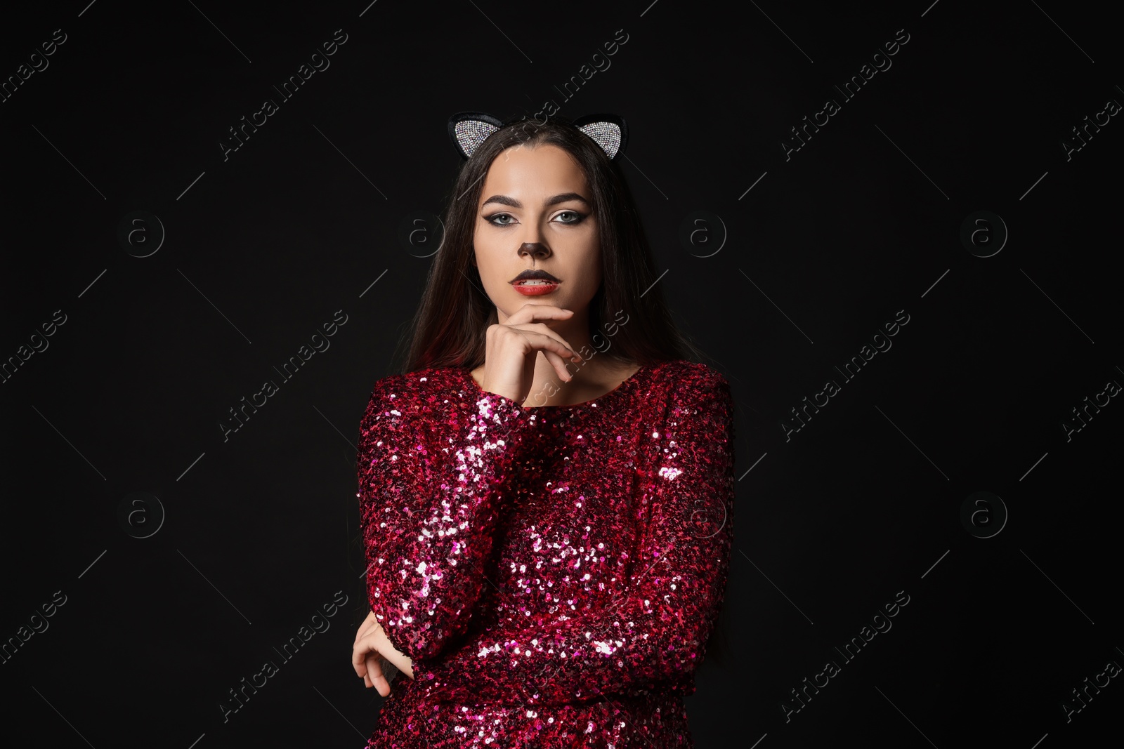 Photo of Charming woman with cat makeup and ears on black background