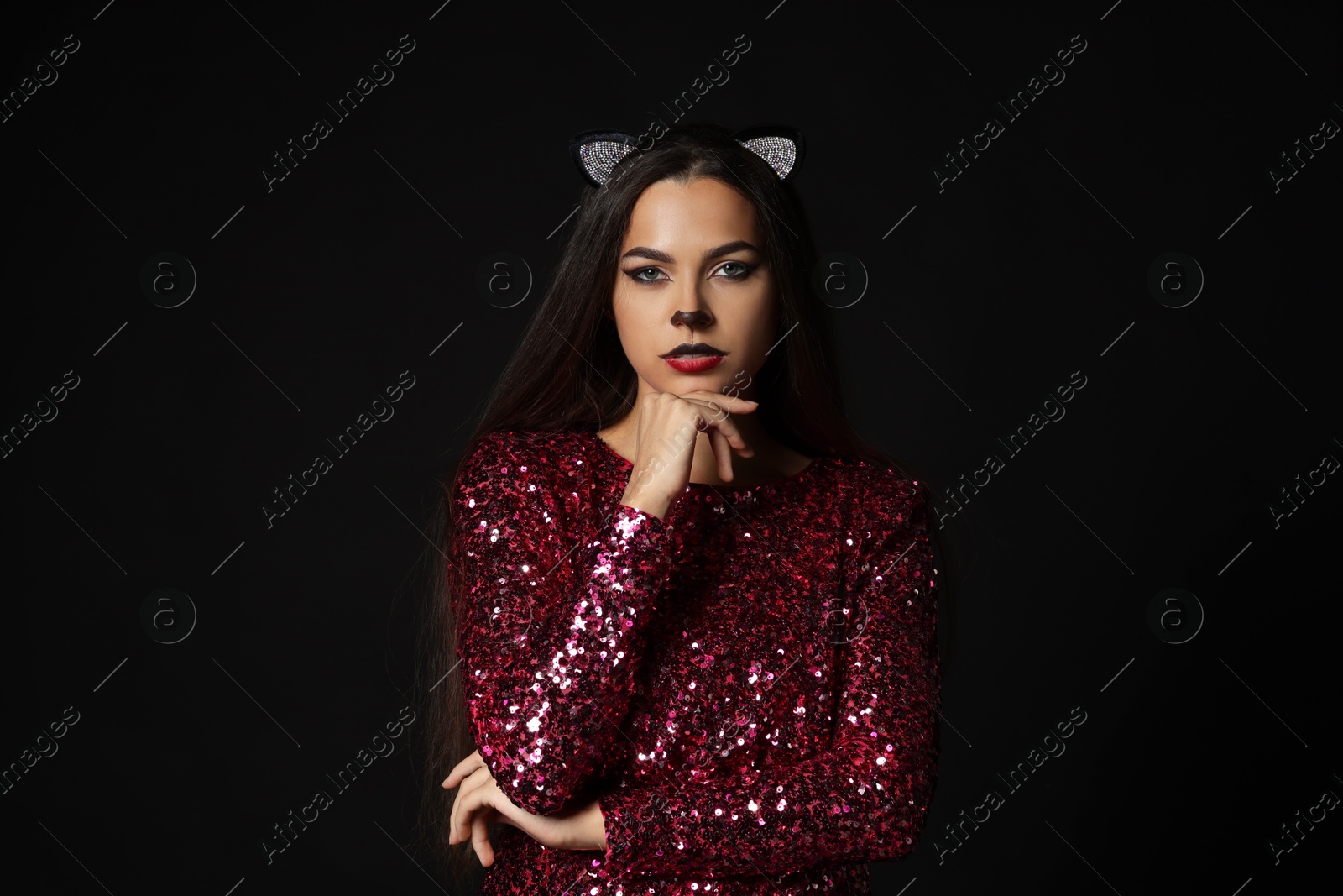 Photo of Charming woman with cat makeup and ears on black background