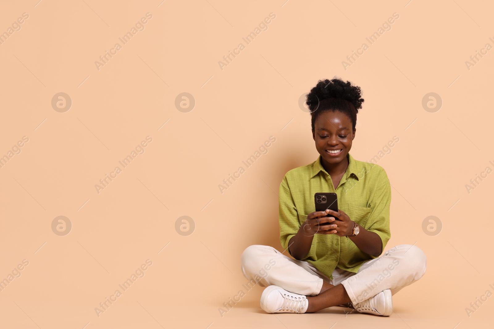 Photo of Happy woman with smartphone on beige background. Space for text