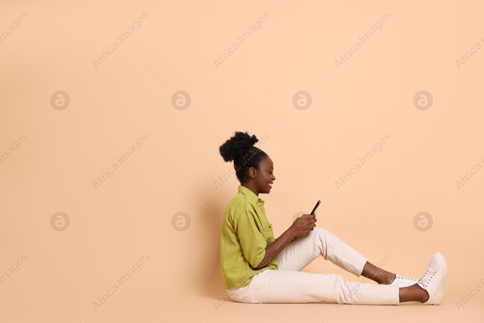 Photo of Happy woman with smartphone on beige background. Space for text