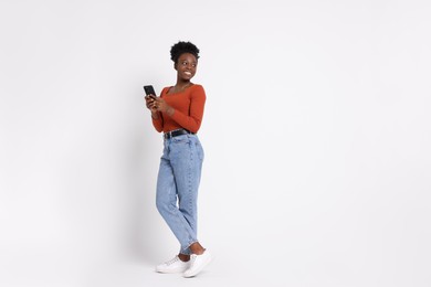 Photo of Happy woman with smartphone on white background. Space for text