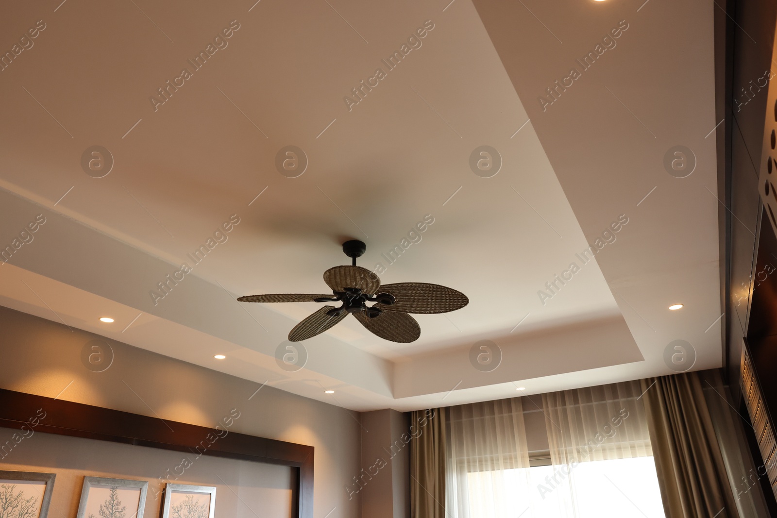 Photo of Modern ceiling fan indoors, low angle view