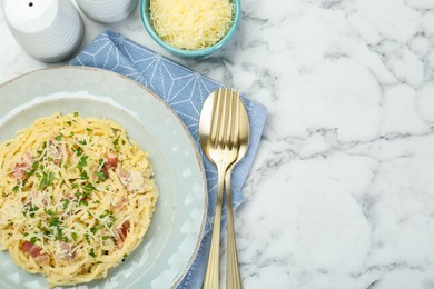 Photo of Delicious pasta Carbonara with bacon served on white marble table, flat lay. Space for text