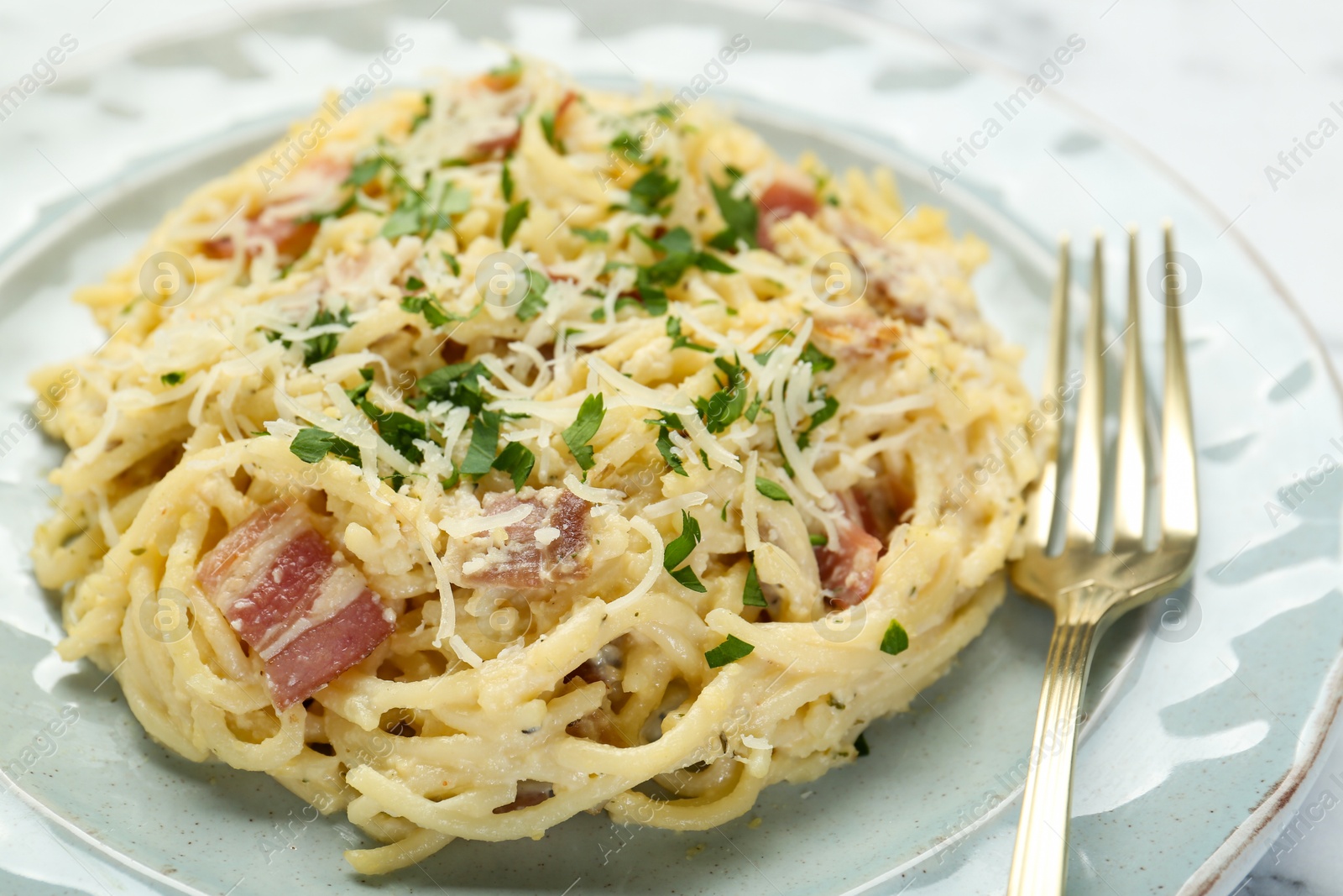 Photo of Delicious pasta Carbonara with bacon served on table, closeup