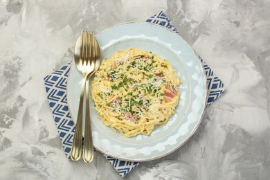 Photo of Delicious pasta Carbonara with bacon served on gray textured table, flat lay