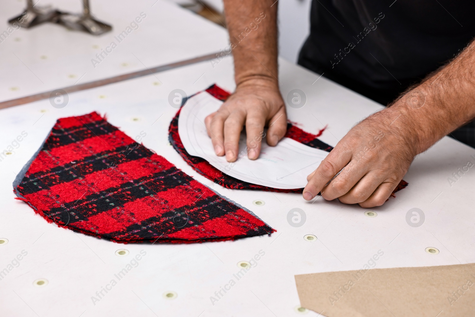 Photo of Man working at white table in professional workshop, closeup