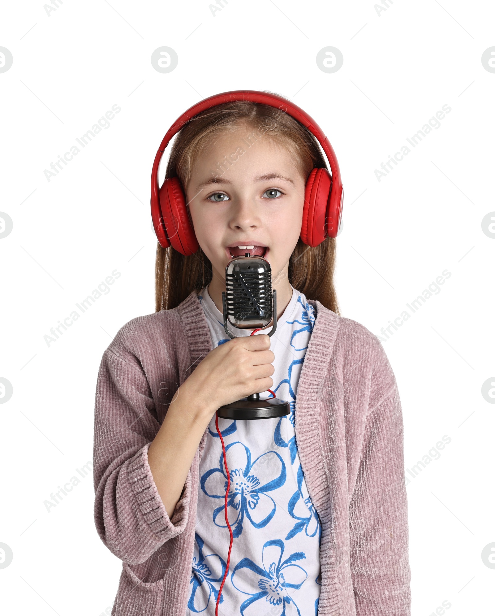 Photo of Little girl with microphone and headphones singing on white background