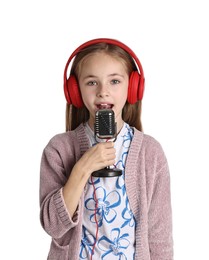 Photo of Little girl with microphone and headphones singing on white background