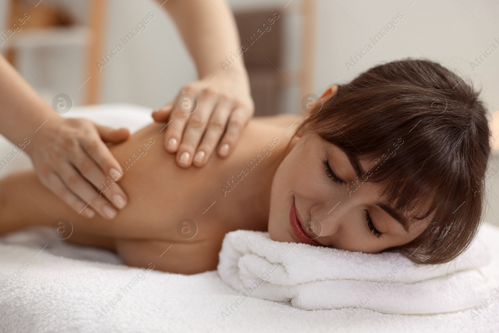 Photo of Young woman receiving massage in spa salon