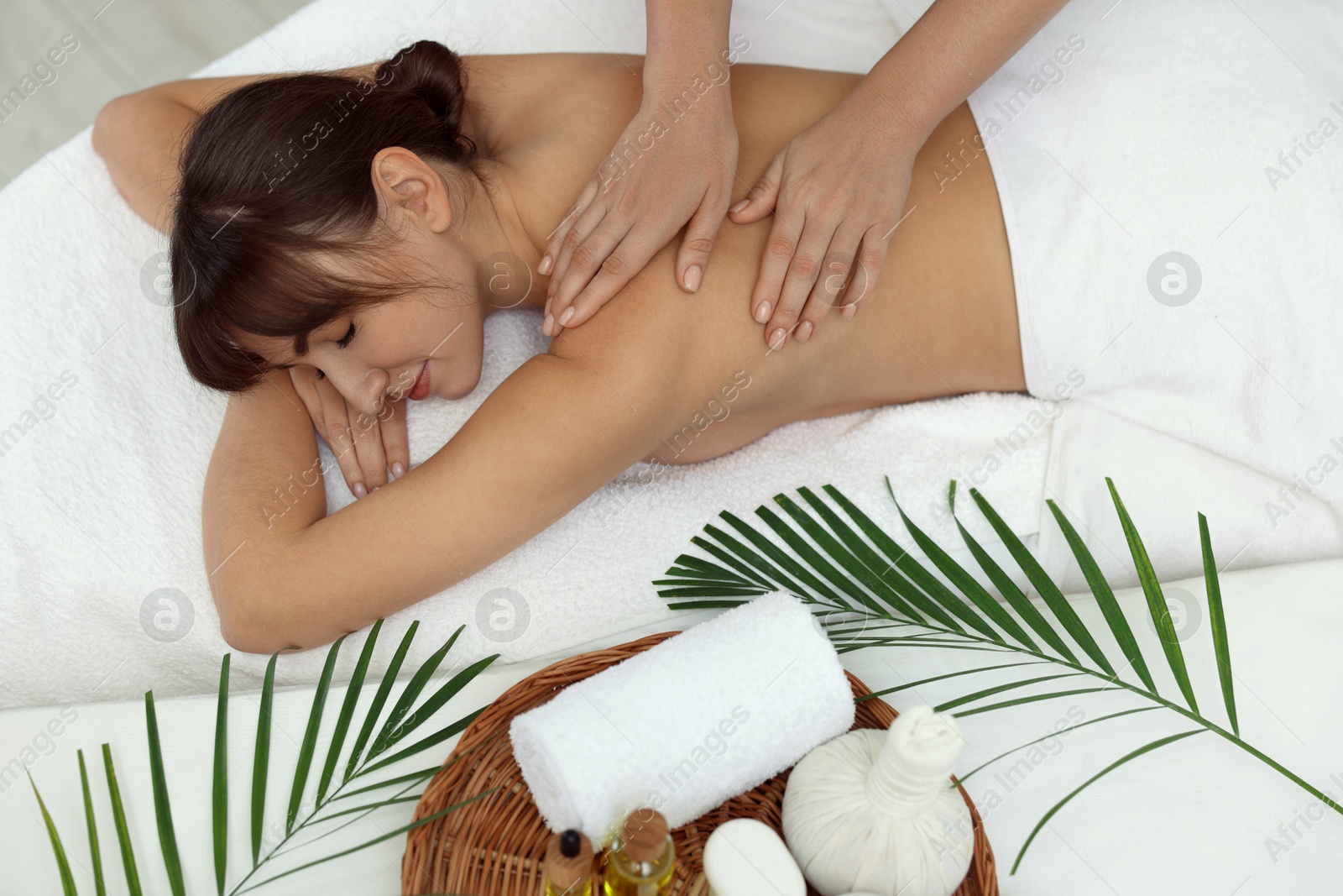 Photo of Young woman receiving massage in spa salon, top view