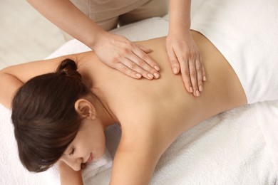 Photo of Young woman receiving massage in spa salon