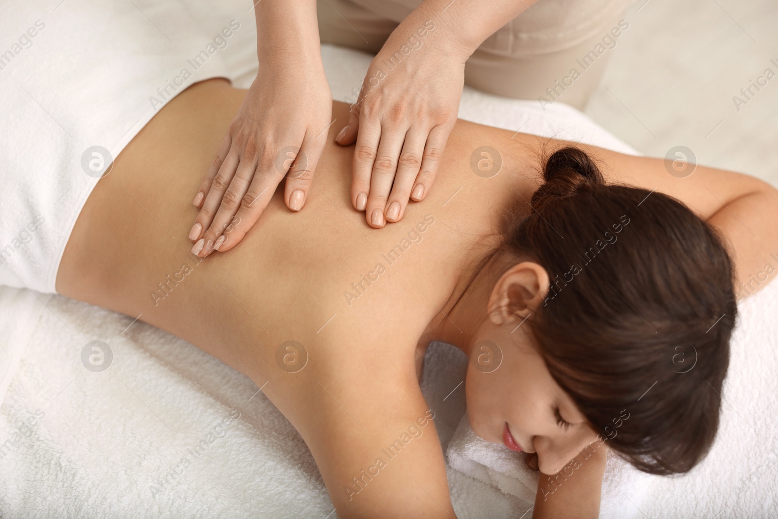 Photo of Young woman receiving massage in spa salon