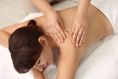 Photo of Young woman receiving massage in spa salon