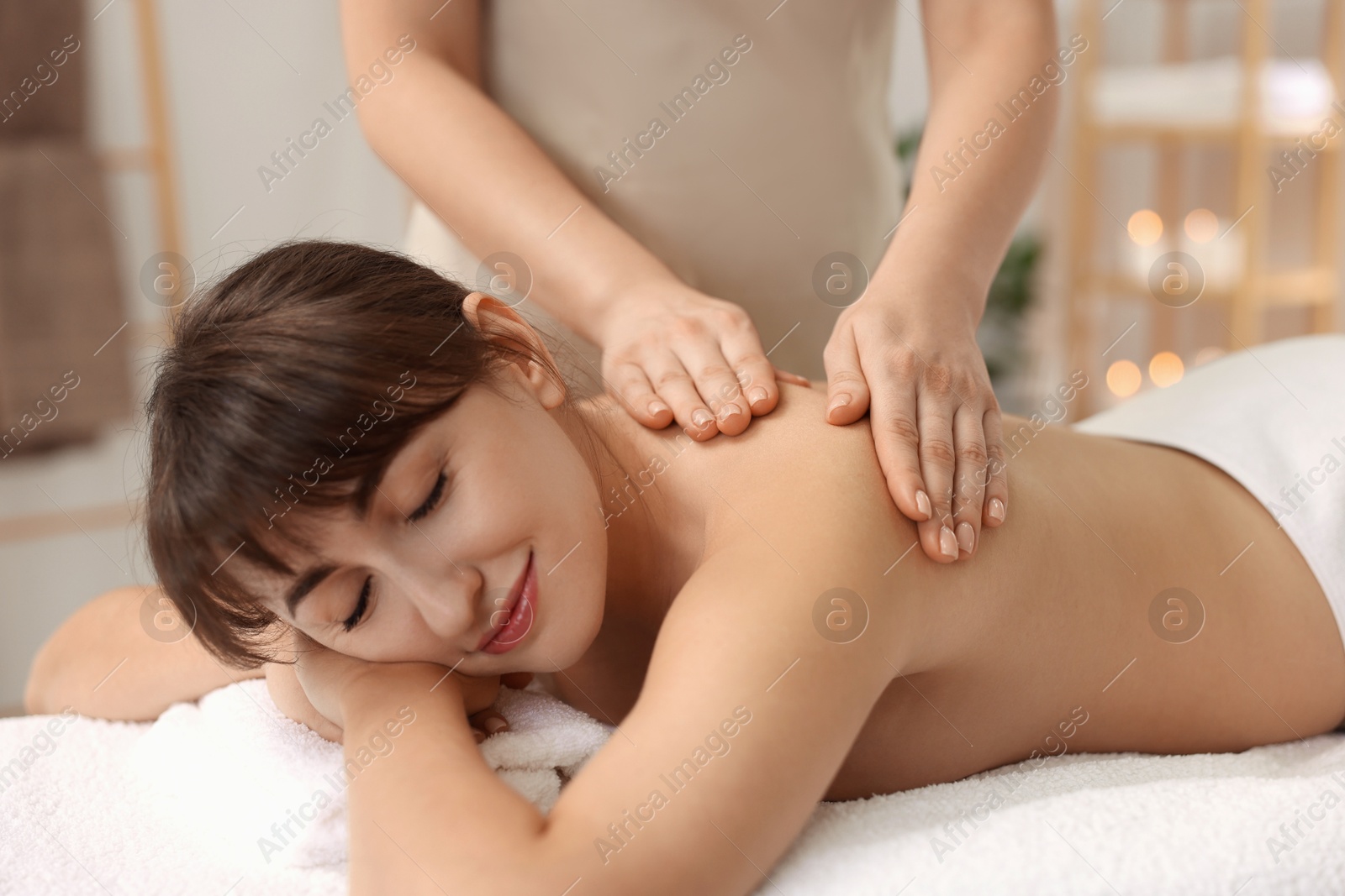 Photo of Young woman receiving massage in spa salon