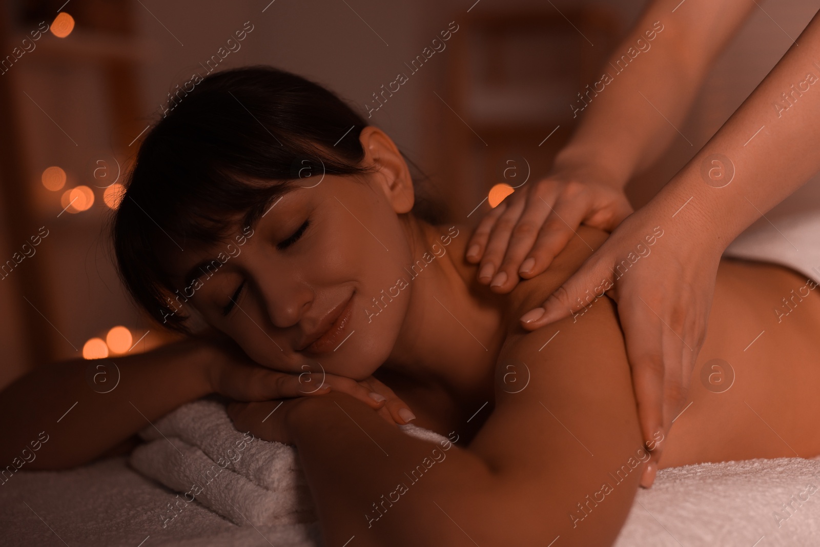 Photo of Young woman receiving massage in spa salon