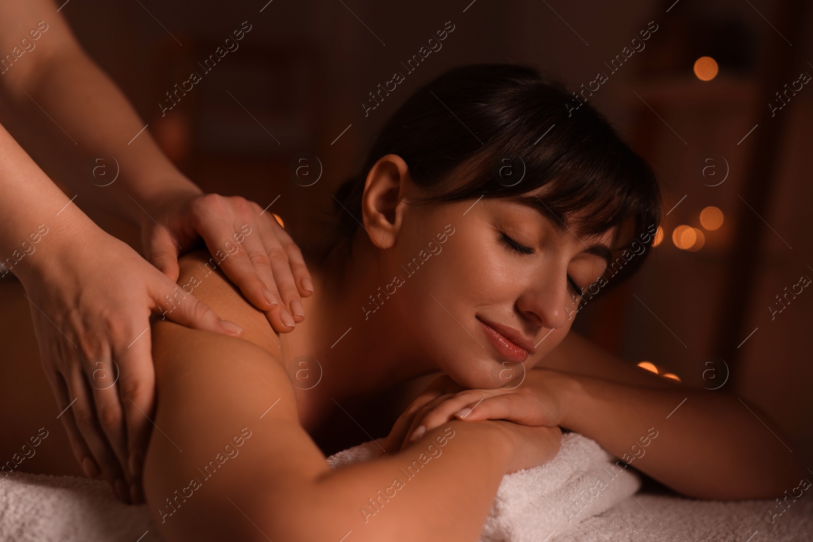 Photo of Young woman receiving massage in spa salon