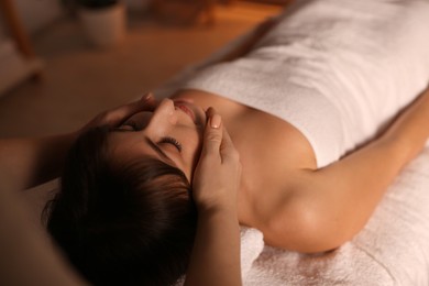 Photo of Young woman receiving massage in spa salon