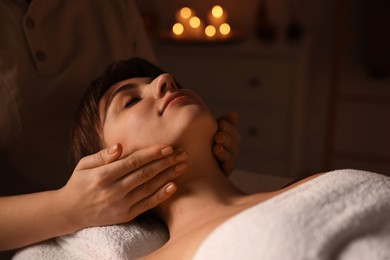 Photo of Young woman receiving face massage in spa salon