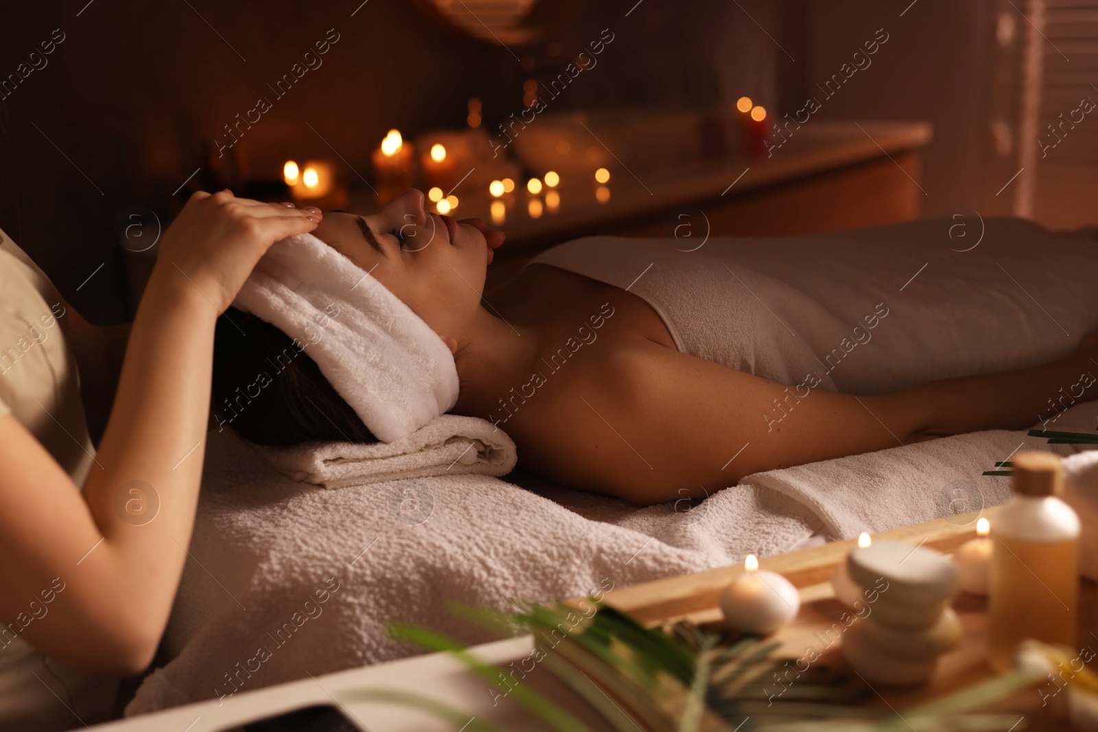 Photo of Young woman receiving massage in spa salon