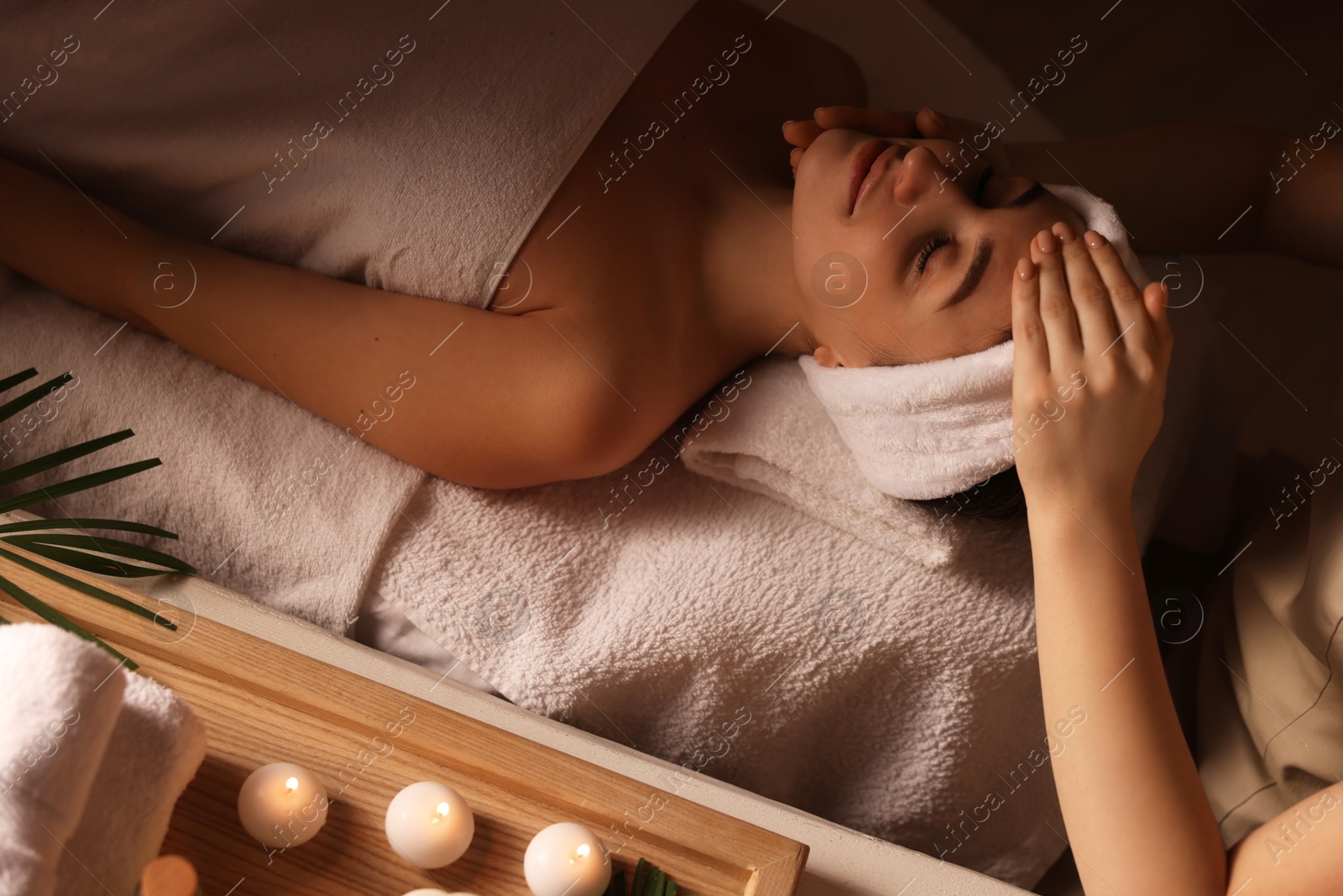 Photo of Young woman receiving massage in spa salon