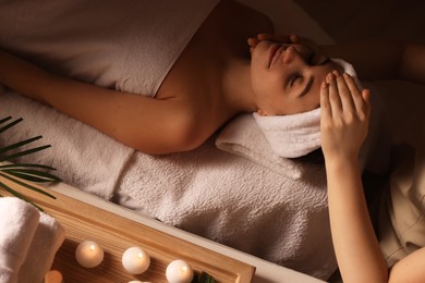 Photo of Young woman receiving massage in spa salon