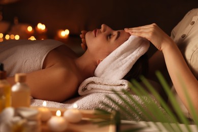 Photo of Young woman receiving massage in spa salon